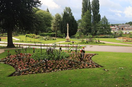 Free A serene outdoor garden scene with lush greenery, flower beds, and pathways in a vibrant park. Stock Photo