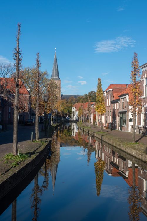 Free Picturesque canal and church steeple in Maasland, Zuid-Holland on a sunny day. Stock Photo