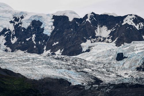 Free Stunning view of an Alaskan glacier surrounded by rugged mountain peaks. Stock Photo