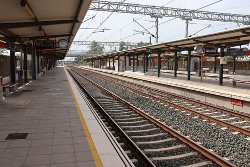 Free A quiet train station platform in Puerto Real, Andalucía, Spain, showcasing rail tracks and shelters. Stock Photo
