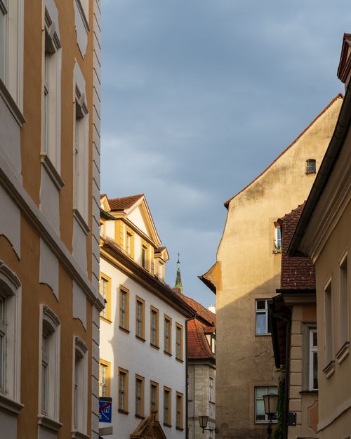 Free A picturesque European street showcasing historic buildings and warm lighting, perfect for architectural exploration. Stock Photo