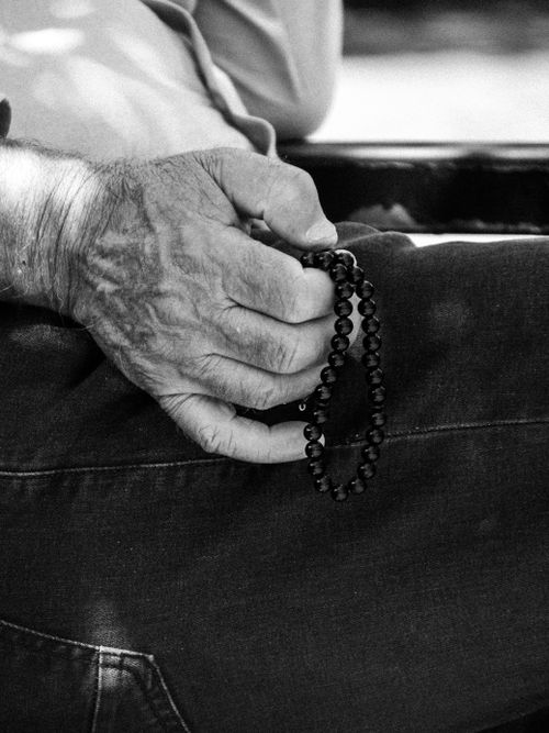 Free Close-up of senior hand holding prayer beads, symbolizing spirituality and peace. Stock Photo