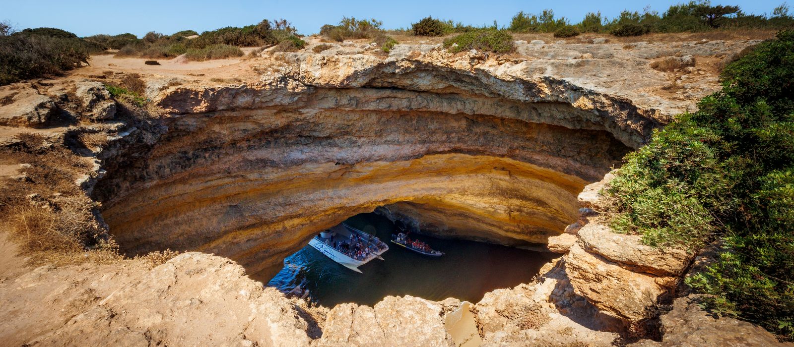 Explore the stunning Benagil Cave in Algarve, Portugal, featuring dramatic rock formations and azure waters.