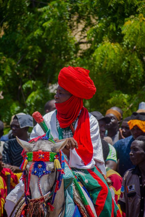 Free Colorful traditional festival with horse rider adorned in vibrant attire and crowd participation. Stock Photo