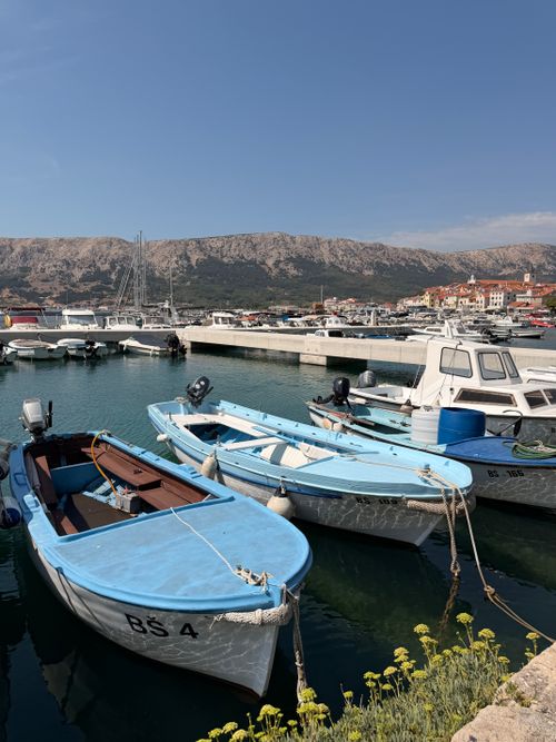 Free Scenic view of blue boats docked at Rijeka harbor with mountains in the background. Stock Photo
