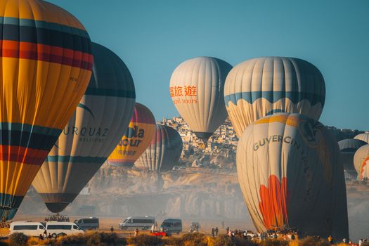 Colorful hot air balloons soar above Cappadocia's unique landscape at sunrise, creating a vibrant travel scene.