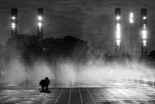 Free A black and white photo of a photographer capturing mist at night in Belo Horizonte, Brazil. Stock Photo