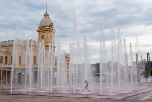 Free A child joyfully plays in a water fountain at Station Square, Belo Horizonte, Brazil. Stock Photo