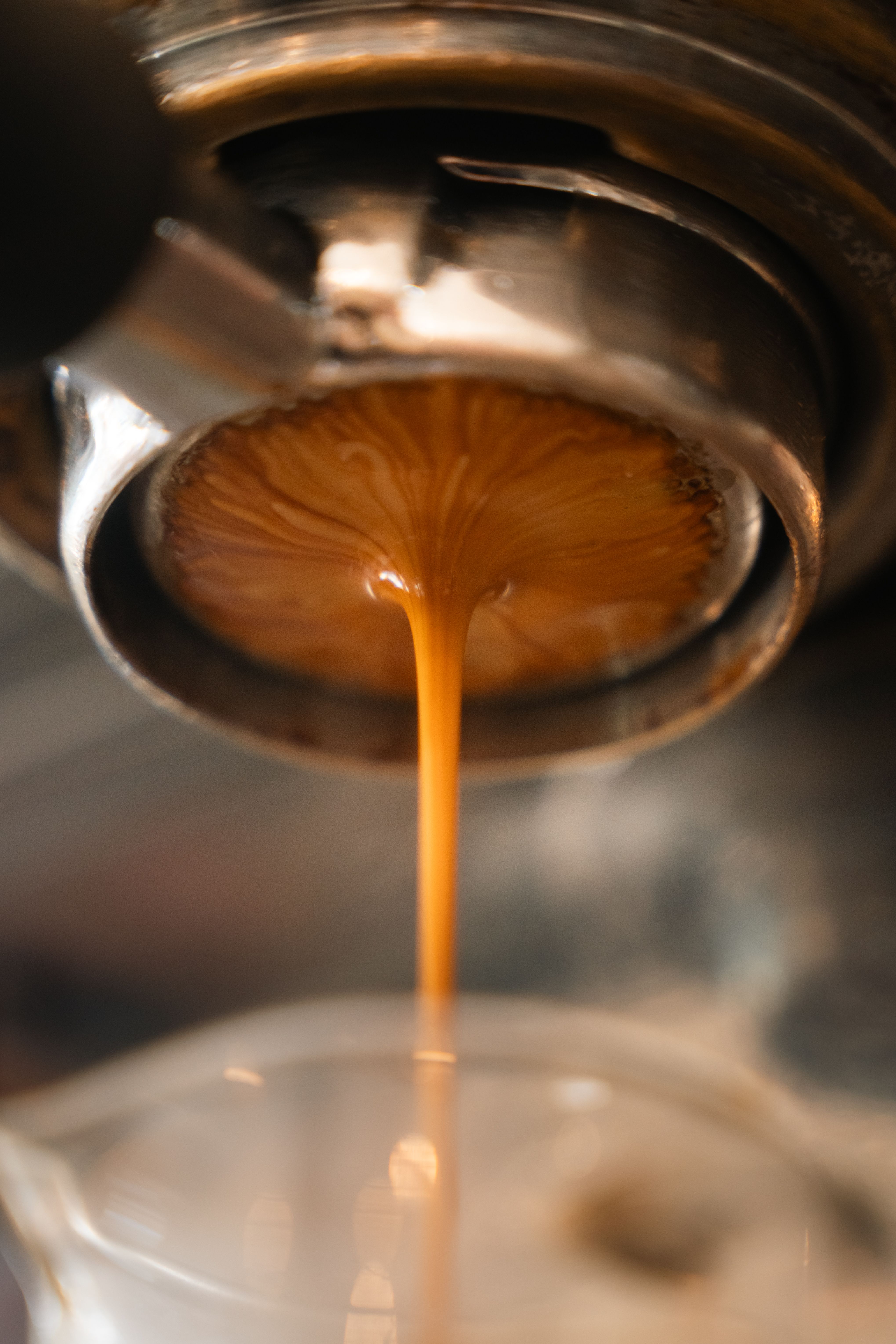 Extracción de espresso con flujo laminar uniforme saliendo del portafiltro sin fondo