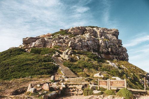 Free A beautiful trail leading to a rocky mountain summit under a bright blue sky. Stock Photo