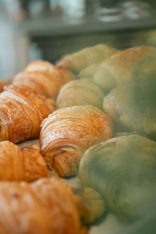 Free Golden brown croissants on a bakery display, showcasing flaky pastry layers. Stock Photo