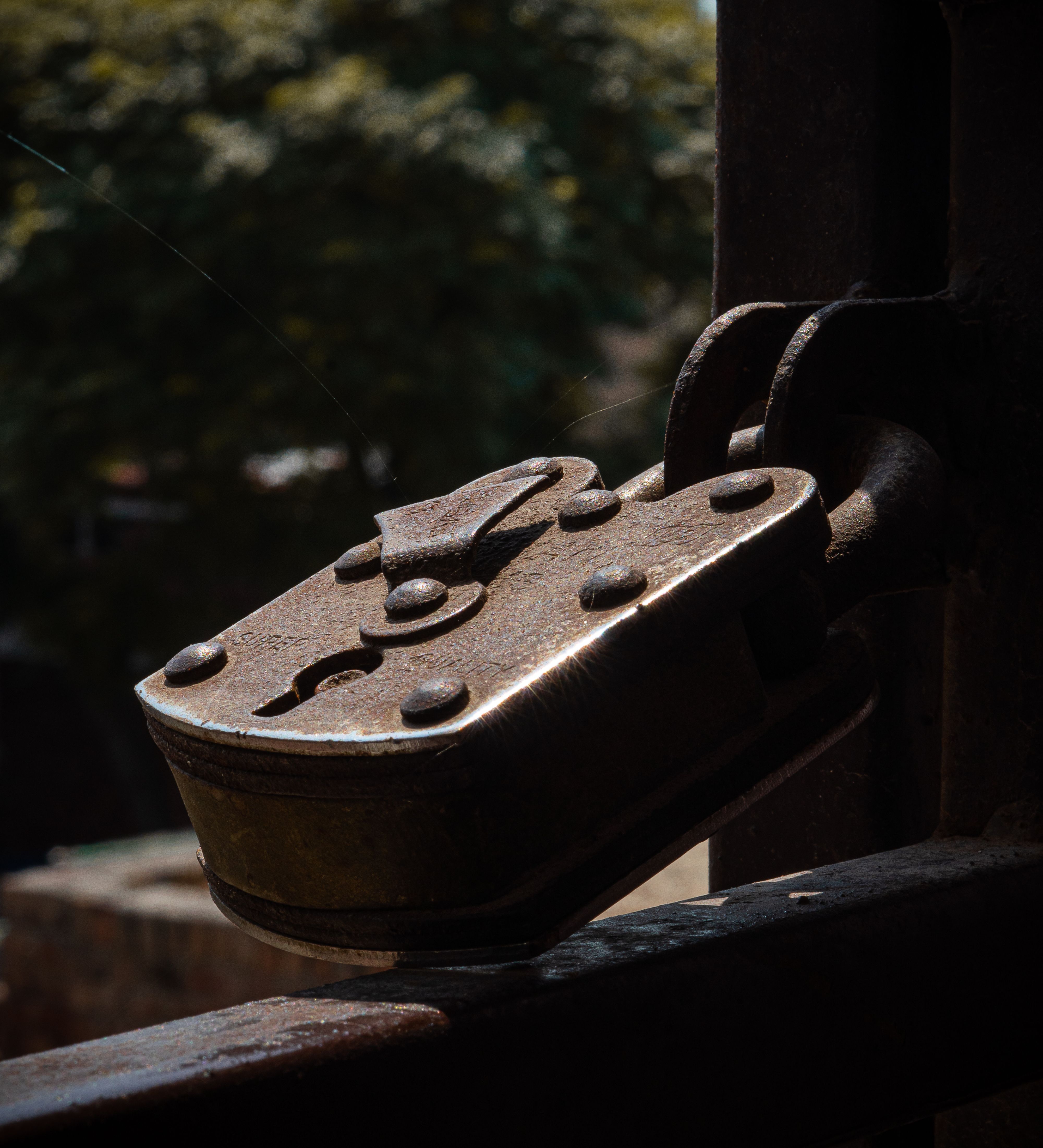 Rusty vintage padlock securely fastened on an old gate, capturing the essence of urban decay.
