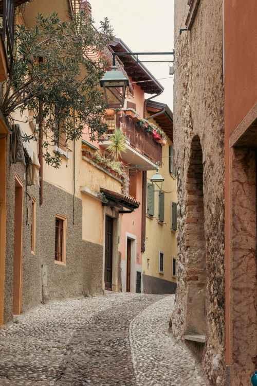 Free Picturesque view of a narrow cobblestone street in a quaint Italian village. Stock Photo