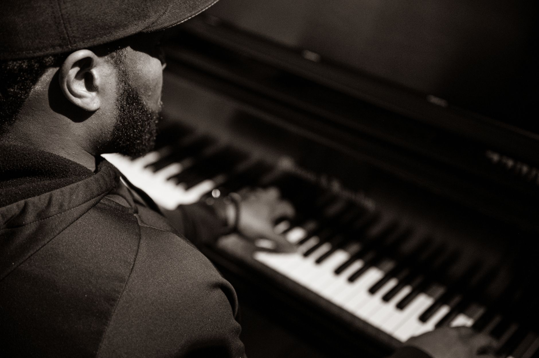 A black and white image capturing a man playing the piano, highlighting musical expression.
