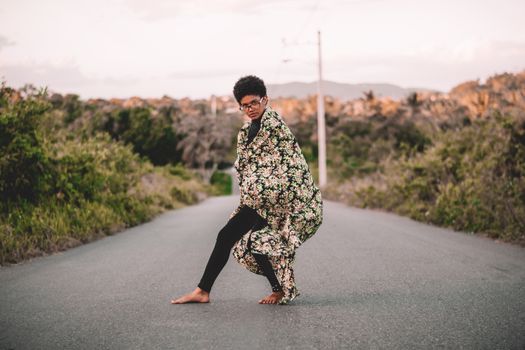 An artistic portrait of a woman posing barefoot on a countryside road in San Cristóbal, Dominican Republic.