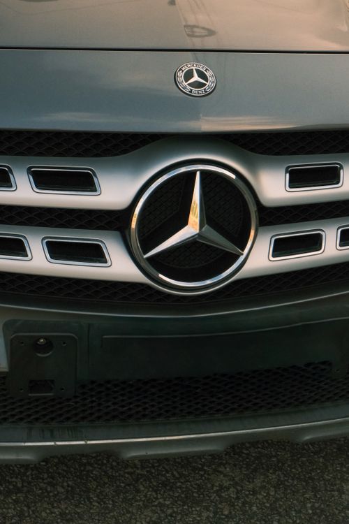 Free Detailed view of a luxury car grille featuring a prominent logo symbol. Stock Photo