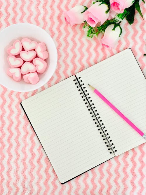 Spiral Notebook On Pink And White Surface