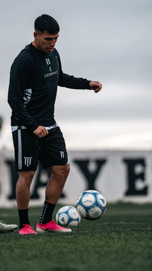 Free Male soccer player practicing dribbling on the field in sportswear. Athletic training session. Stock Photo