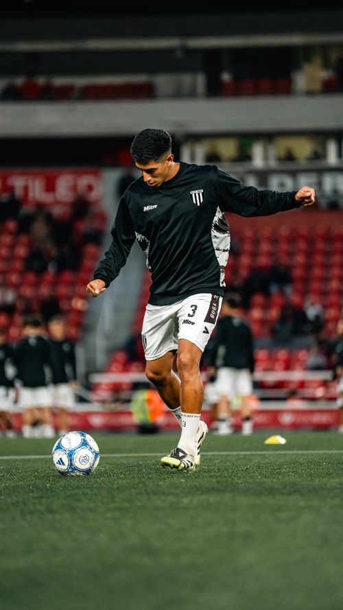 Free Soccer player practicing with a ball on the field during team warm-up session at stadium. Stock Photo
