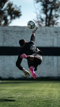 Goalkeeper diving save on a soccer field, showcasing athleticism and agility.