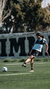Professional soccer player practicing on field during sunny day.