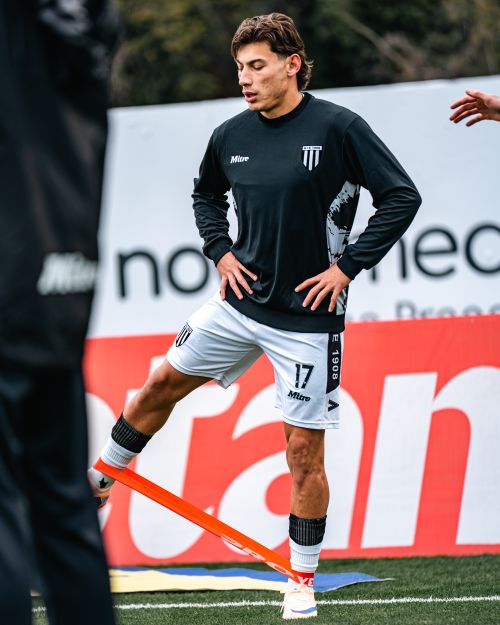 Free Soccer player exercises with resistance band during outdoor training session. Sports fitness focus. Stock Photo