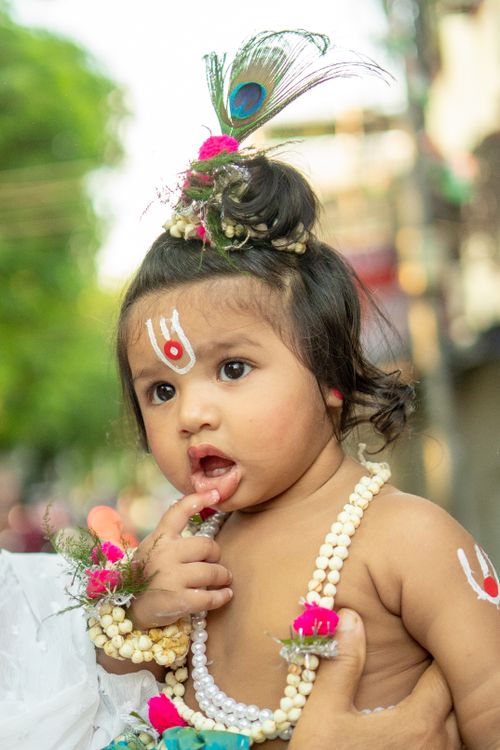 Free Cute baby adorned in traditional headdress and jewelry, outdoors. Stock Photo
