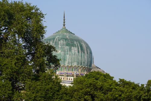 Free Historic Qutub Shahi Tomb with verdant dome surrounded by lush trees in Hyderabad. Stock Photo