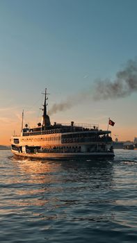 A scenic view of a ferry cruising on the Bosporus in Istanbul during sunset, capturing the city's iconic skyline.