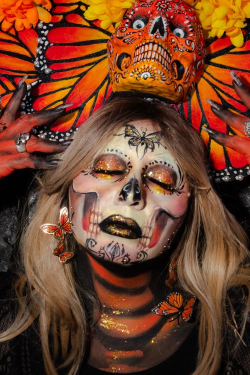 Free A striking Día de los Muertos portrait with skull makeup and butterfly accessories. Stock Photo