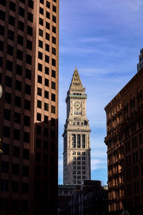 Free Iconic Custom House Tower framed by nearby buildings under a clear blue sky. Stock Photo