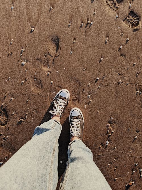Free Casual sneakers on sandy beach at Shorncliffe, Australia. Perfect summer footwear shot. Stock Photo
