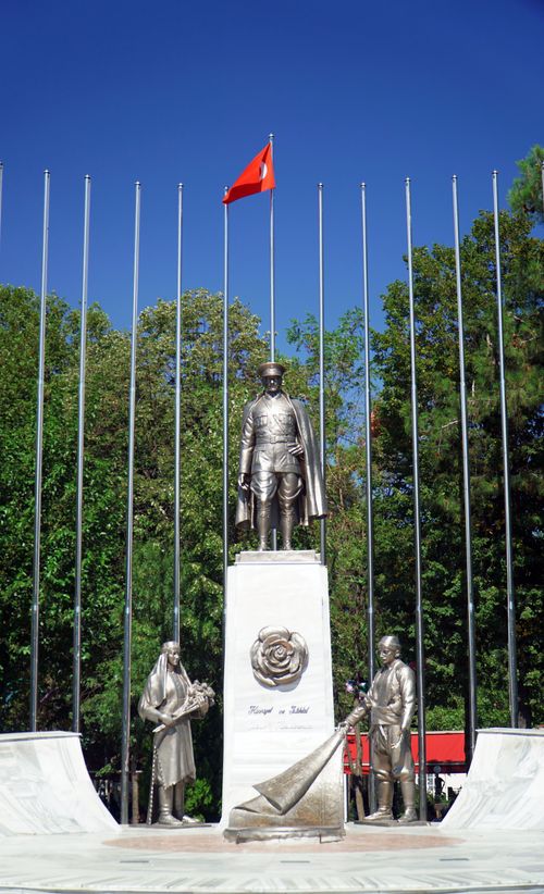 Free Statue of Atatürk in Isparta, Türkiye, adorned with Turkish flag and surrounded by greenery. Stock Photo