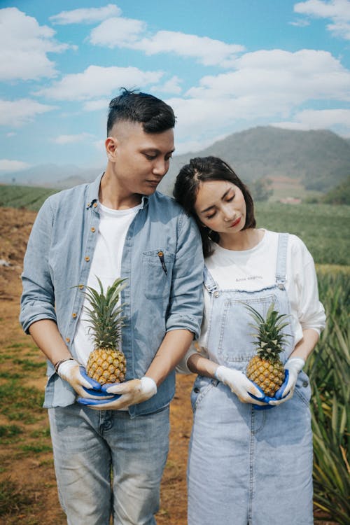 Man And Woman Holding Pineapple Fruit