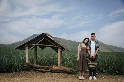 Man And Woman Standing Near Crops