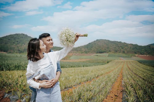 Man Hugging Woman Holding A Bouquet