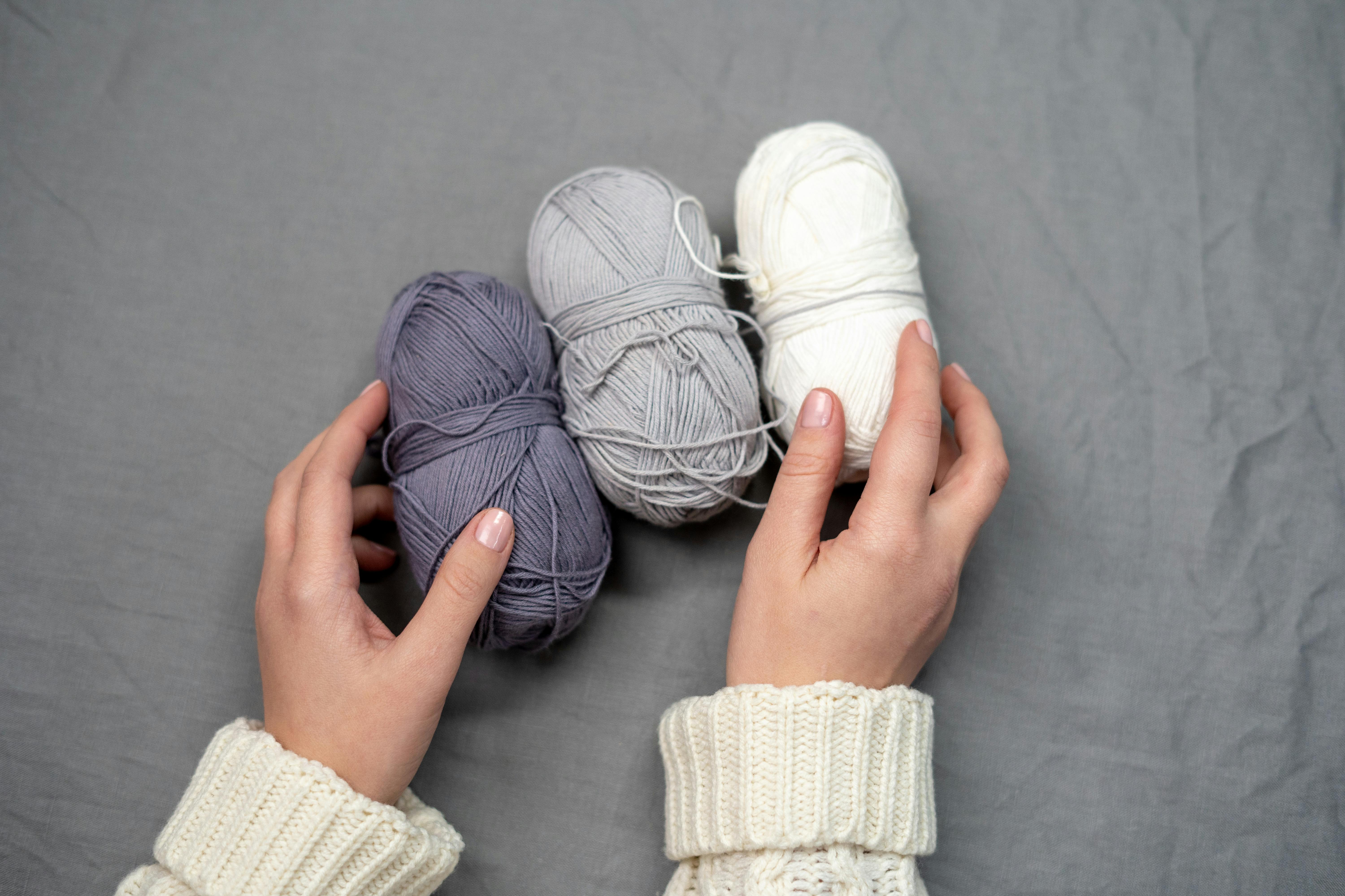 person holding blue yarn roll