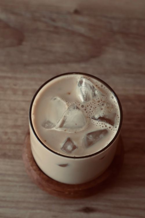 Free Chilled iced coffee with milk in a glass on a rustic wooden table. Stock Photo