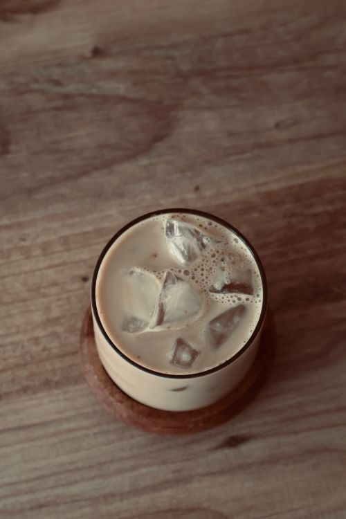Free Top-down view of iced coffee with milk on a rustic wooden table. Stock Photo