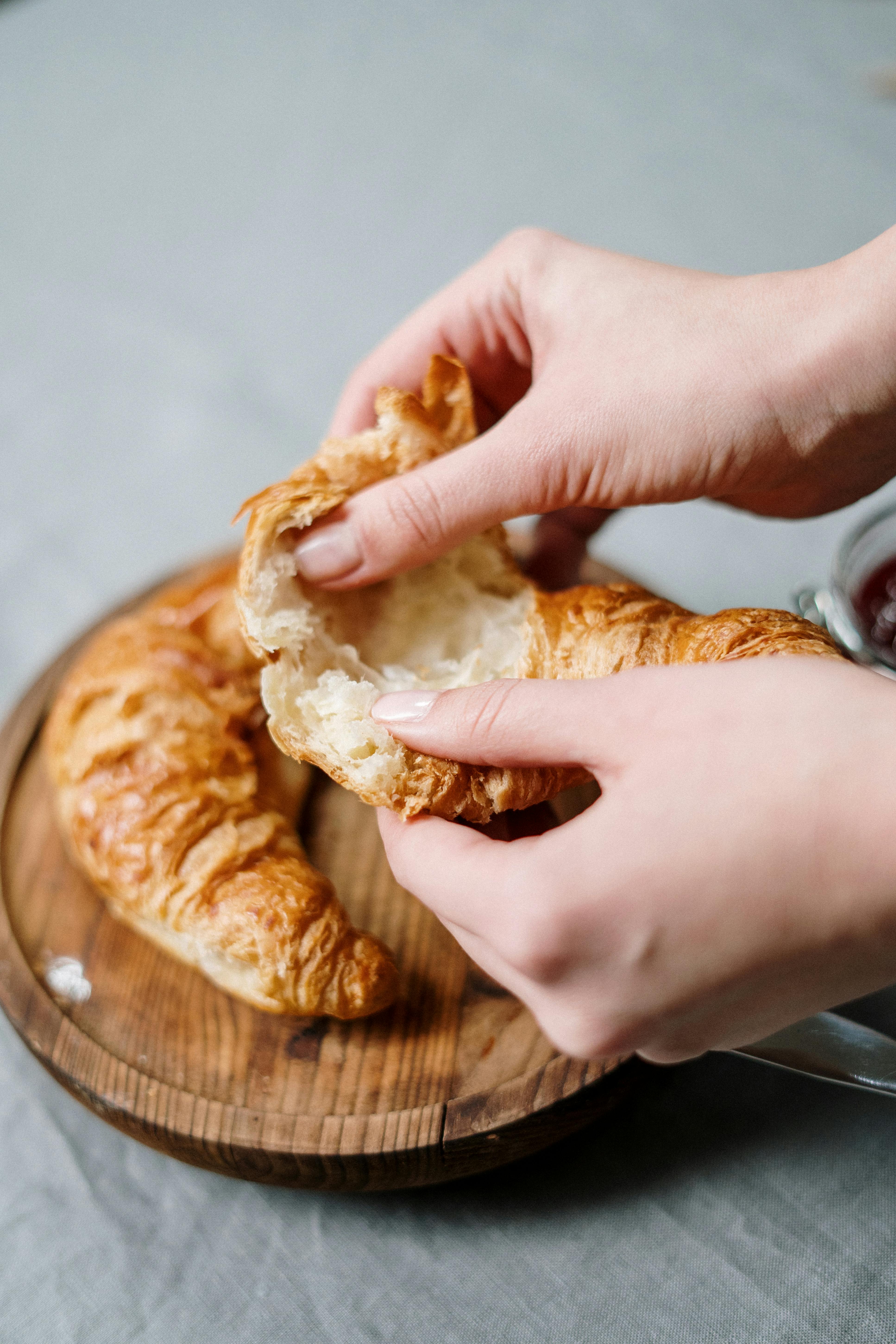 person holding bread with white cream