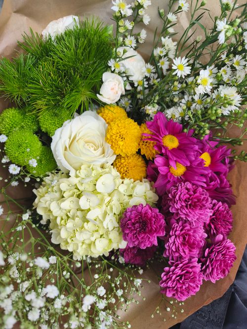 Free A colorful bouquet featuring roses, daisies, chrysanthemums, and marigold blossoms. Perfect for celebrations. Stock Photo