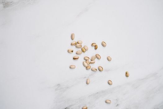 大理石背景上散落着开心果，非常适合美食和生活方式主题