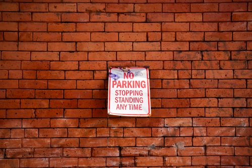 Free A red "No Parking" sign on a rustic brick wall in Ottawa, Canada. Stock Photo