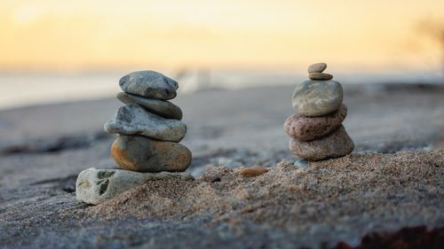 Free Tranquil stone stacks on a serene beach during sunrise, symbolizing balance and harmony. Stock Photo