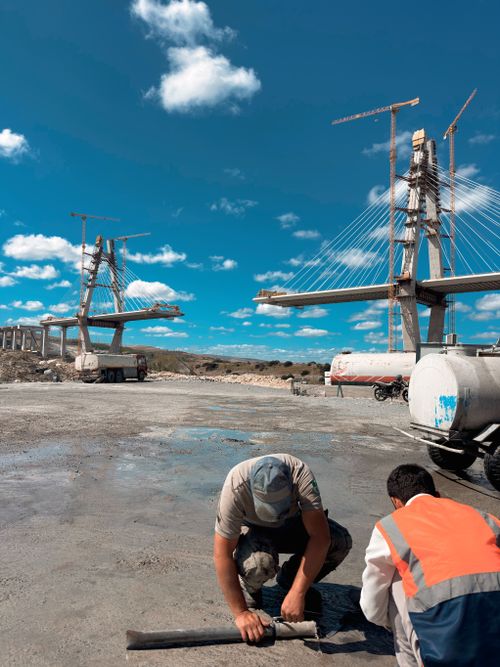 Free Engineers work on the foundation of a large bridge under construction on a sunny day. Stock Photo