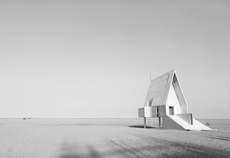 Grayscale Photo Of Wooden House On The Beach