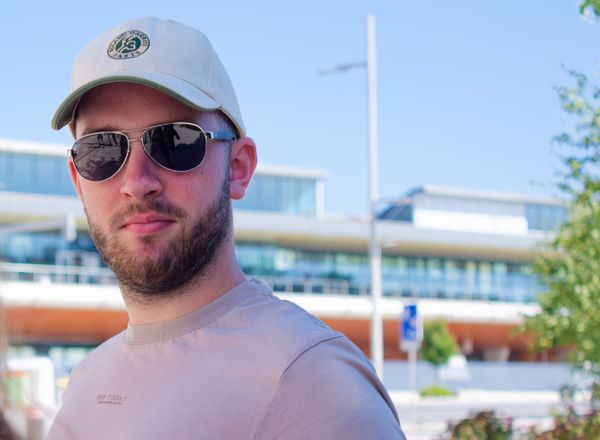 Portrait en gros plan d'un homme en lunettes de soleil et casquette blanche