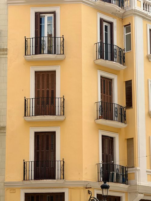 Free Beautiful beige facade of a historic apartment building with elegant balconies in Málaga. Stock Photo