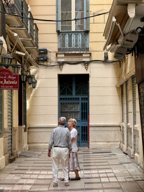 Free An elderly couple enjoying a stroll through a quaint street in Málaga, Spain. Stock Photo
