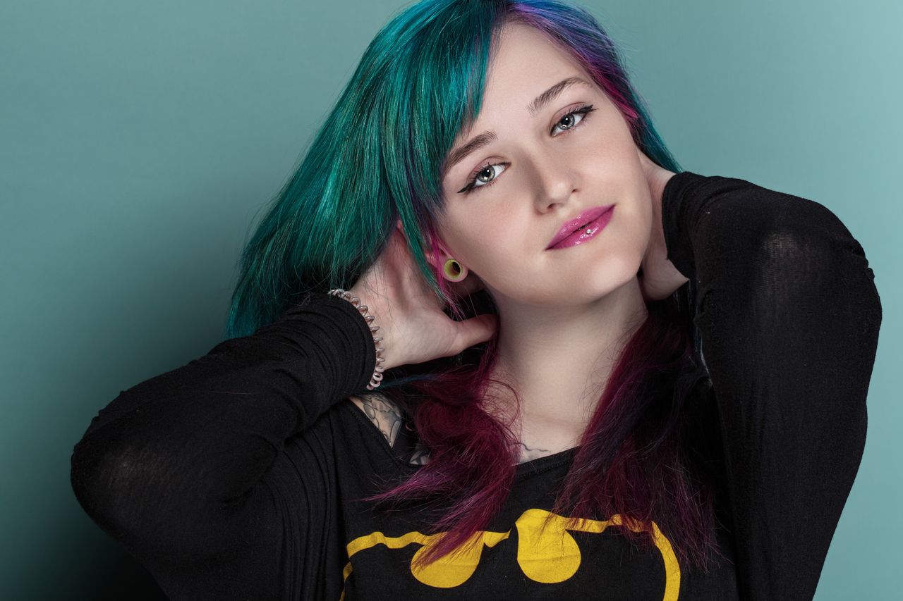 stylish portrait of a woman with colorful hair and vibrant makeup in a
